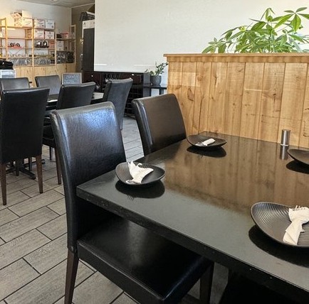 Dining room at Bao Su with black leather chairs and dark tables