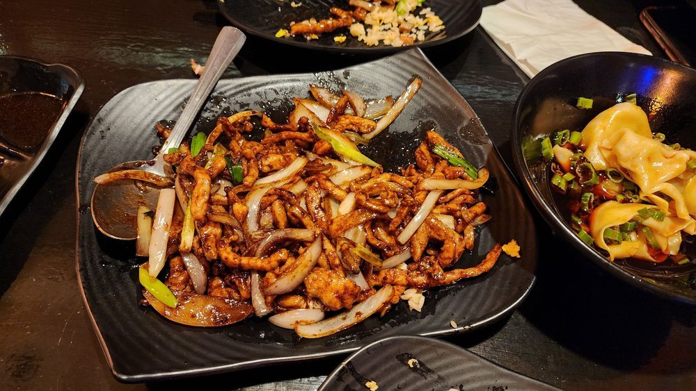Stir-fried shredded meat with onion and scallion, wontons in chili oil beside it, at Bao Su