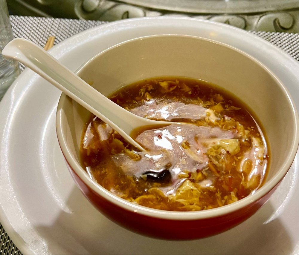 Bowl of hot and sour soup with a porcelain spoon